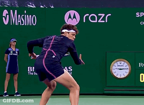 A Tennis Player Is Swinging A Racket In Front Of A Rolex Clock GIF