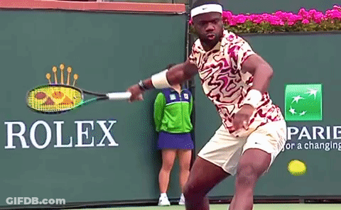 A Tennis Player Is Swinging A Racket In Front Of A Rolex Sign GIF