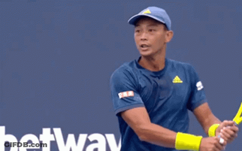 A Tennis Player Is Swinging A Racket In Front Of A Tau Sign GIF
