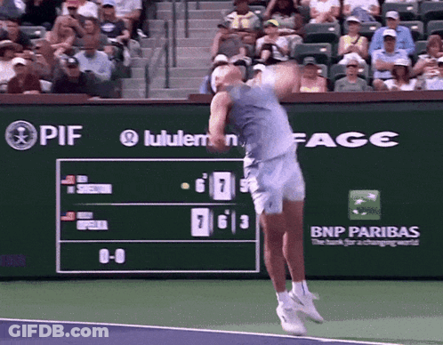 A Tennis Player Is Swinging A Tennis Racket In Front Of A Scoreboard That Says Bnp Paribas GIF