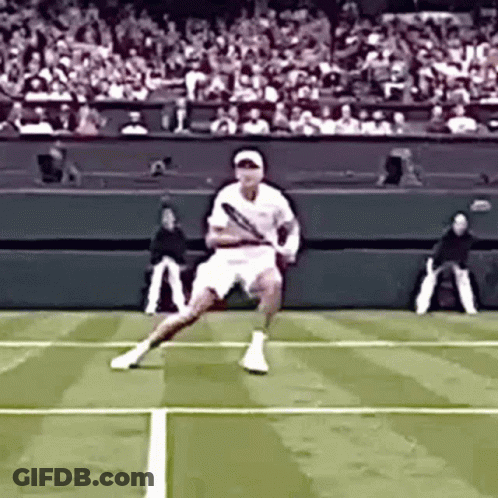 A Tennis Player Is Swinging A Tennis Racquet On A Court GIF