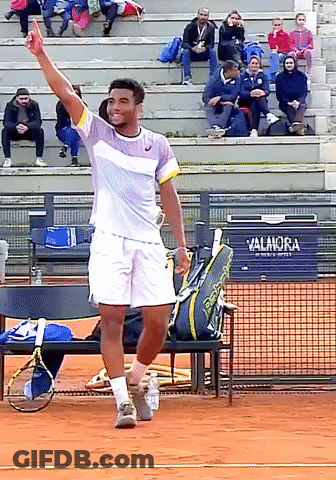 A Tennis Player On A Court With A Sign That Says Valanora GIF
