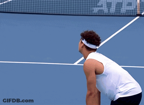 A Tennis Player Reaches For A Tennis Ball On A Court That Has A Lacos Sign On It GIF