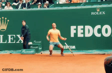 A Tennis Player Stands In Front Of A Green Wall That Says Fedco GIF
