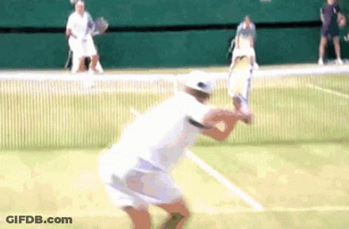 A Tennis Player Swings A Racket At A Tennis Ball GIF