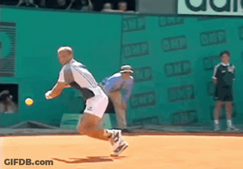 A Tennis Player Throws A Tennis Ball On A Court With An Ad For Adidas In The Background GIF