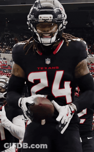 A Texans Football Player Is Holding A Football In His Hands GIF