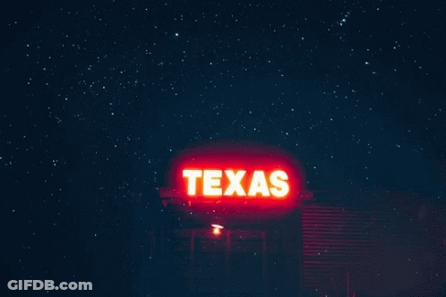 A Texas Sign Is Lit Up At Night With A Starry Sky In The Background GIF