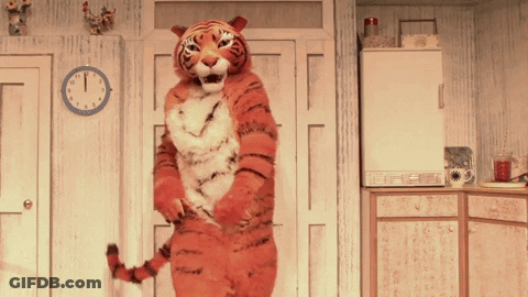 A Tiger Costume Is Standing In Front Of A Clock That Shows The Time As 1:15 GIF
