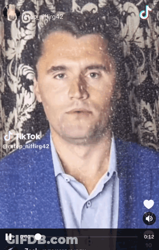 A Tiktok Video Of A Man In A Suit And Blue Shirt GIF