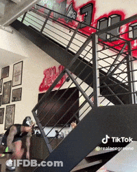 Person Jumping Down Stairs With Graffiti Wall GIF