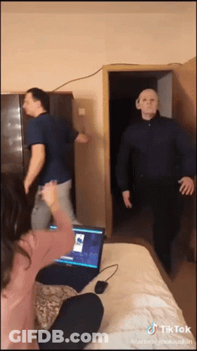 A Tiktok Video Shows A Man Wearing A Mask And A Woman Sitting In Front Of A Laptop GIF