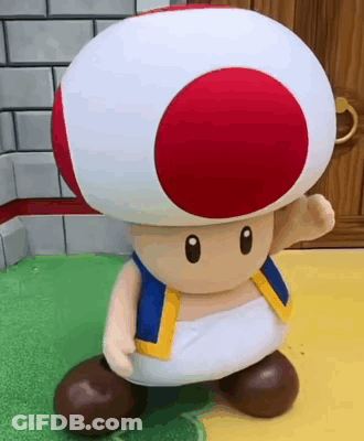 A Toad From Super Mario Bros Is Standing On A Green Surface . GIF
