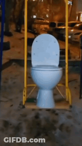 A Toilet Is Hanging From A Yellow Pole In A Playground . GIF