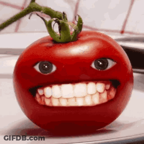 A Tomato With A Big Smile On It 'S Face Is Sitting On A Plate . GIF