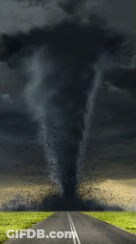 A Tornado Is Coming Down The Road In The Middle Of A Field GIF