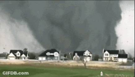 A Tornado Is Moving Through A Residential Area With Houses In The Background . GIF