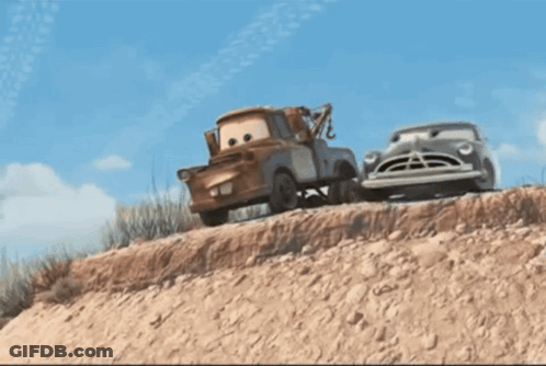 A Tow Truck Is Pulling A Car Down A Dirt Hill GIF