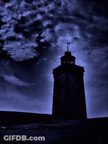 A Tower With A Cross On Top Of It Is Silhouetted Against A Dark Blue Sky GIF