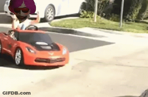 A Toy Car Is Driving Down A Street With A Person Driving It . GIF