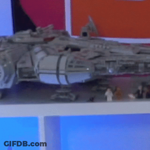A Toy Falcon Sits On A Shelf Next To A Few Lego Figures GIF
