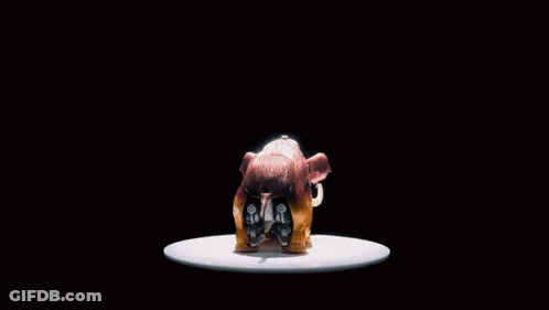 A Toy Robot Is Standing In Front Of A Black Background With Chinese Writing Behind It GIF