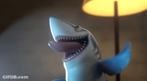 A Toy Shark With Its Mouth Open And Its Tongue Hanging Out GIF