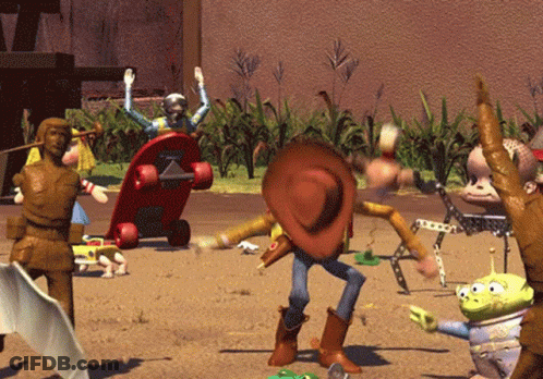 A Toy Story Scene With Woody And Aliens In The Sand GIF