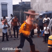 A Toy Story Woody Mascot Is Walking Down The Street . GIF