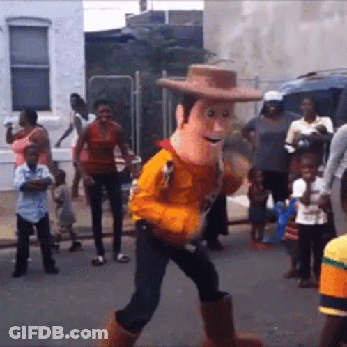 A Toy Story Woody Mascot Walking Down A Street GIF