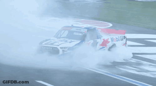 A Toyota Truck Is Driving Down A Race Track With Smoke Coming Out Of It GIF