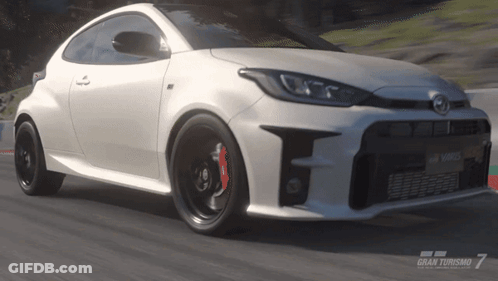 A Toyota Yaris Is Driving Down A Road In A Video Game Called Gran Turismo 7 GIF