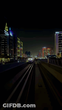A Train Is Going Down The Tracks In The Dark GIF