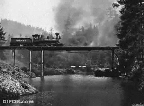 A Train Is Going Over A Bridge Over A River In A Black And White Photo . GIF