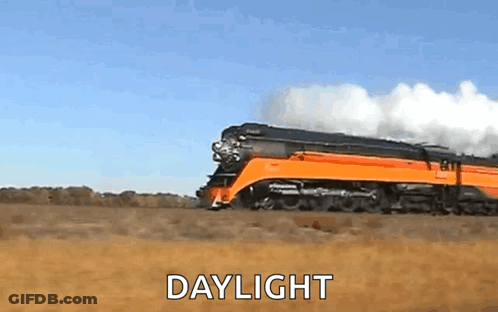 A Train Is Going Through A Field With The Words Daylight Below It . GIF