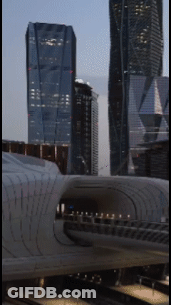 A Train Is Going Through A Tunnel In Front Of A City Skyline GIF