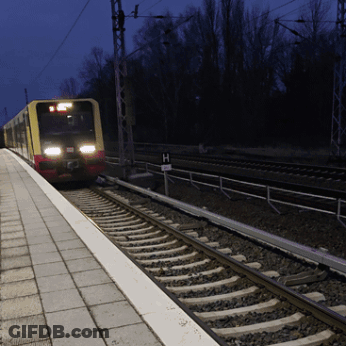 A Train Is Pulling Into A Station With A Sign That Says H GIF
