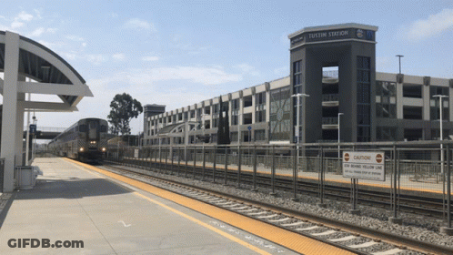 A Train Station With A Sign That Says " Caution " On It GIF