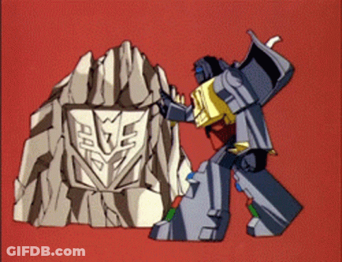 A Transformer Is Standing Next To A Rock With A Shield On It GIF