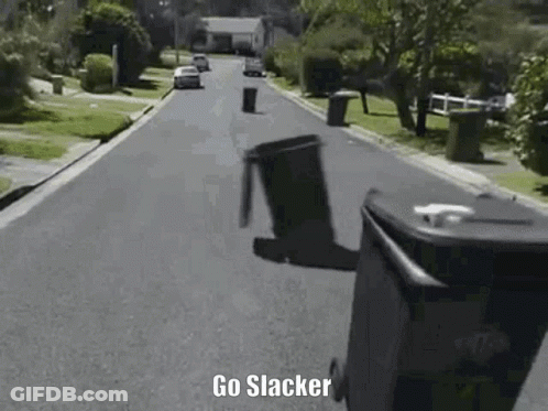 A Trash Can Is Flying Through The Air On The Side Of A Street . GIF