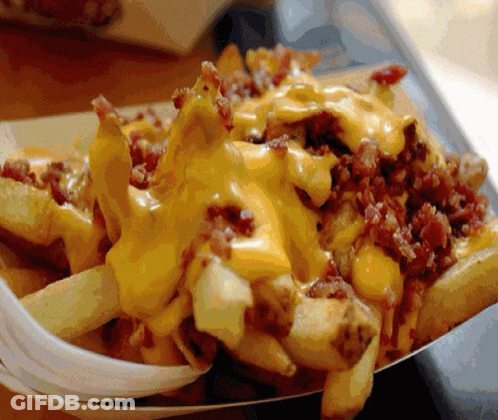 A Tray Of French Fries With Cheese And Bacon On Them GIF