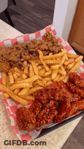 A Tray Of Fried Chicken And French Fries On A Checkered Napkin GIF