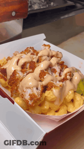 A Tray Of Macaroni And Cheese With Fried Chicken And Ranch Dressing GIF