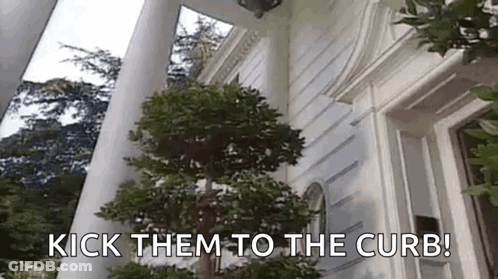 A Tree In Front Of A White House With The Words `` Kick Them To The Curb '' Written On It . GIF
