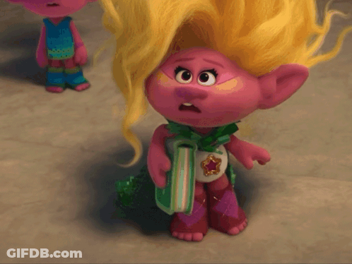 A Troll Doll With Blonde Hair Is Holding A Gift GIF