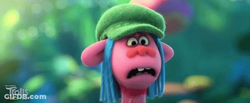 A Troll Wearing A Green Hat And Blue Hair Is Making A Funny Face . GIF