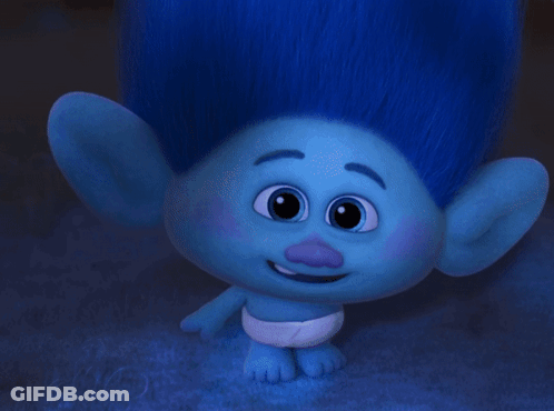 A Troll Wearing Glasses And A Diaper Looks At The Camera GIF