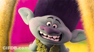 A Troll With A Purple Nose Is Smiling And Wearing A Green Scarf GIF