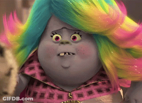 A Troll With A Rainbow Colored Wig Is Making A Surprised Face . GIF