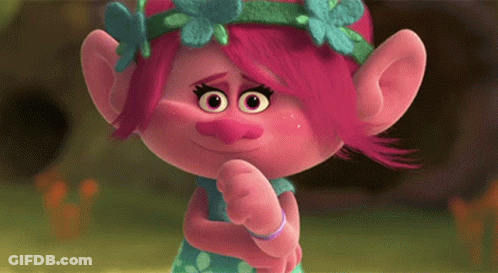 A Troll With Pink Hair And A Flower Crown On Her Head Is Making A Funny Face . GIF